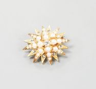 An Edwardian yellow metal, graduated split pearl and single stone diamond set starburst brooch(