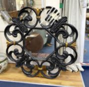 A large black painted and parcel gilt Italian style wall mirror, with octagonal plate, width