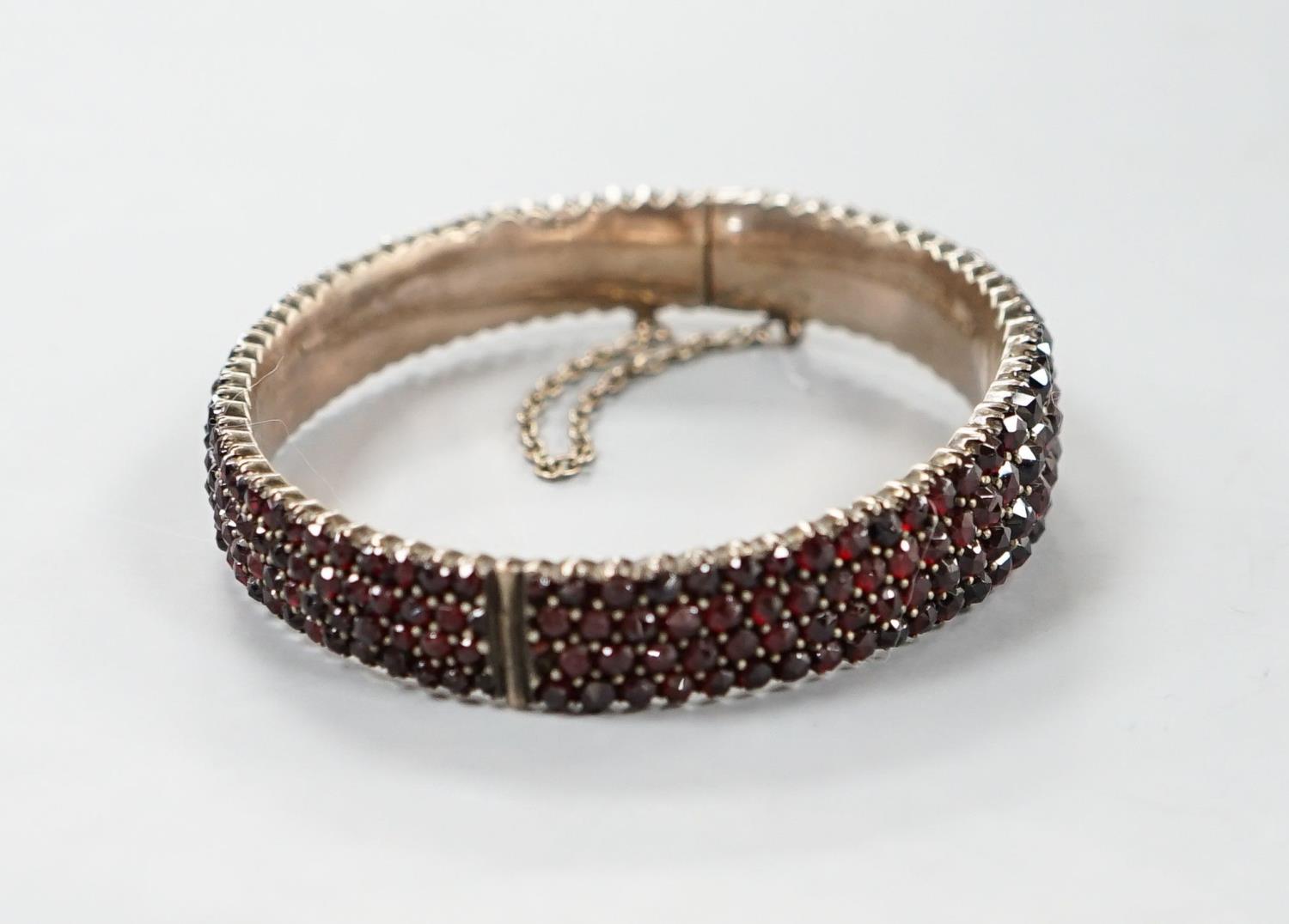 A late Victorian gilt white metal and garnet encrusted hinged bangle (stone missing). - Image 4 of 4