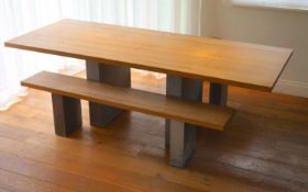 A contemporary oak kitchen table with pair of matching benches and oxidised metal supports, table