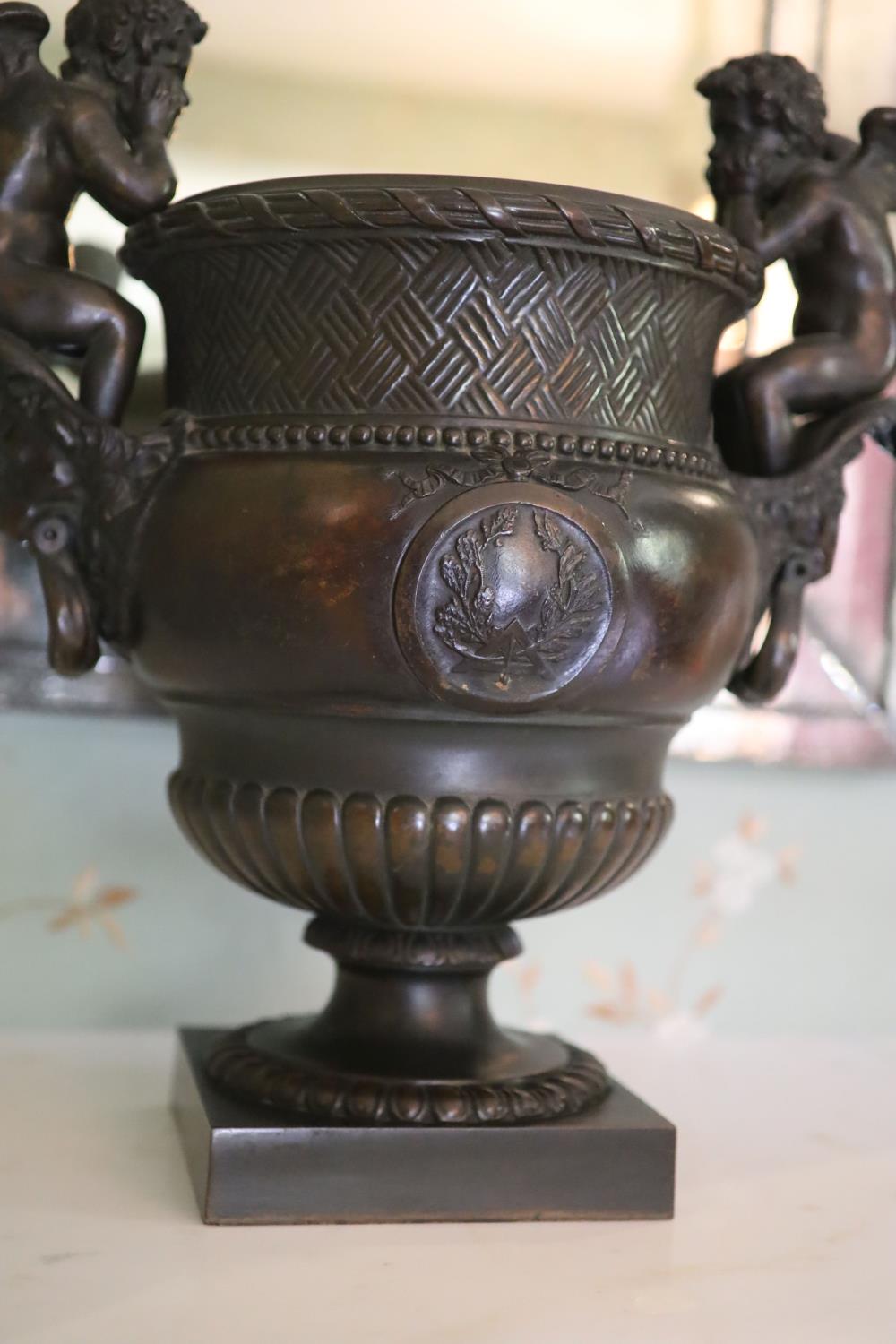 A classical style bronze urn modelled with disconsulate cherubs, height 44cm width 40cm - Image 4 of 4