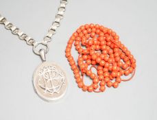 A white metal oval locket with monogram, 43mm, on a fancy white metal chain and a string of coral