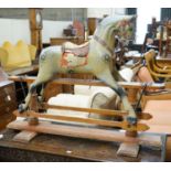 An Edwardian carved wood and dapple painted rocking horse, raised in a trestle frame, length