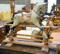 An Edwardian carved wood and dapple painted rocking horse, raised in a trestle frame, length