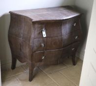 A three drawer bombe commode, upholstered in simulated snake skin, width 102cm depth 51cm height