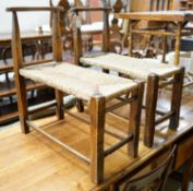 A pair of French provincial oak and beech stools with elongated rush seats, width 31cm, length 67cm,