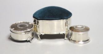 An Edwardian silver mounted pin cushion, Birmingham, 1909, length 10cm and two George V silver and