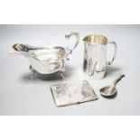 A George V silver sauceboat, a silver jug with military related inscription, a silver cigarette case