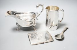 A George V silver sauceboat, a silver jug with military related inscription, a silver cigarette case