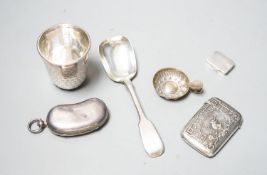 A George V silver twin sovereign kidney shaped case, 65mm, a silver spoon, silver tot , silver