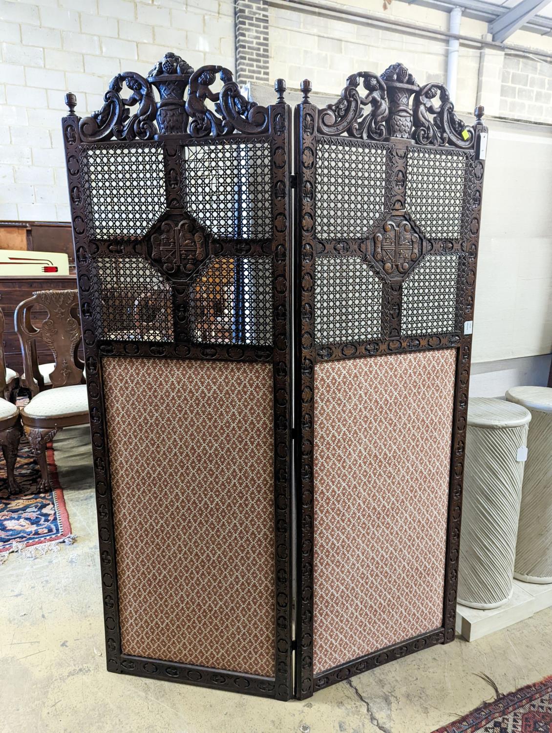 A 1920's carolean style oak and cane work two fold dressing screen, each panel width 60cm, height