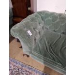 A late Victorian double drop arm Chesterfield settee upholstered in green fabric, length 186cm,