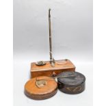 A Victorian cased weighing scale, two papier mache wine coasters and surveyor's measure.