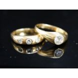 A modern 18ct gold and gypsy set solitaire diamond ring, size X and a similar three stone diamond