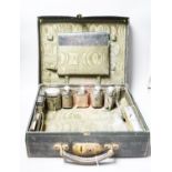 An Edwardian Harrod's traveling toilet case, fitted with six silver mounted toilet accessories,