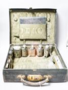 An Edwardian Harrod's traveling toilet case, fitted with six silver mounted toilet accessories,