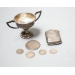 A silver vesta case, a small silver trophy cup and five assorted coins including a Charles II half