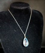 An 18ct mounted facetted pear cut aquamarine set pendant, 33mm, on a 375 white metal fine link