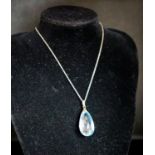 An 18ct mounted facetted pear cut aquamarine set pendant, 33mm, on a 375 white metal fine link