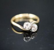 An 18ct & plat, two stone diamond crossover ring, size J, gross weight 1.8 grams.