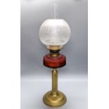 A Victorian brass oil lamp with etched glass shade and cranberry reservoir. 64cm total height