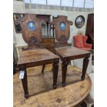 A pair of Victorian oak hall chairs with painted armorials, width 43cm, depth 39cm, height 94cm