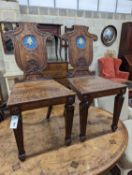 A pair of Victorian oak hall chairs with painted armorials, width 43cm, depth 39cm, height 94cm