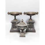 A pair of bronze tazzas on architectural slate bases, c.1900, together with a third, associated