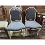 A pair of grey upholstered dining chairs