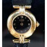 A lady's gilt white metal Must De Cartier quart wrist watch, on a Cartier leather strap.