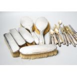 Six assorted silver mounted clothes and hair brushes and a small group of sterling handled cutlery.