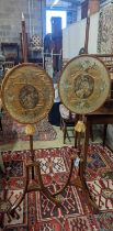 A pair of 19th century mahogany pole screens, with oval silkwork banners, height 148cm