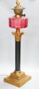 And early 20th century Corinthian column brass and cranberry glass oil lamp, converted for