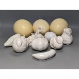 A decorative collection of tin glazed model fruits, together with three ostrich eggs