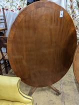 Attributed to William Tillman. A reproduction George III style oval mahogany pedestal tilt top