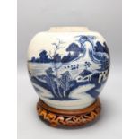 An 18th century Chinese provincial blue and white jar on a wooden stand. 25cm including stand