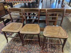 A set of three Regency provincial simulated rosewood cane seated dining chairs