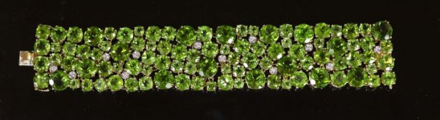 A Continental 18k gold and graduated round cut peridot encrusted bracelet, with twelve stone diamond