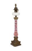 A Victorian ormolu mounted Bohemian ruby overlaid glass oil lamp,enamelled with floral sprays on