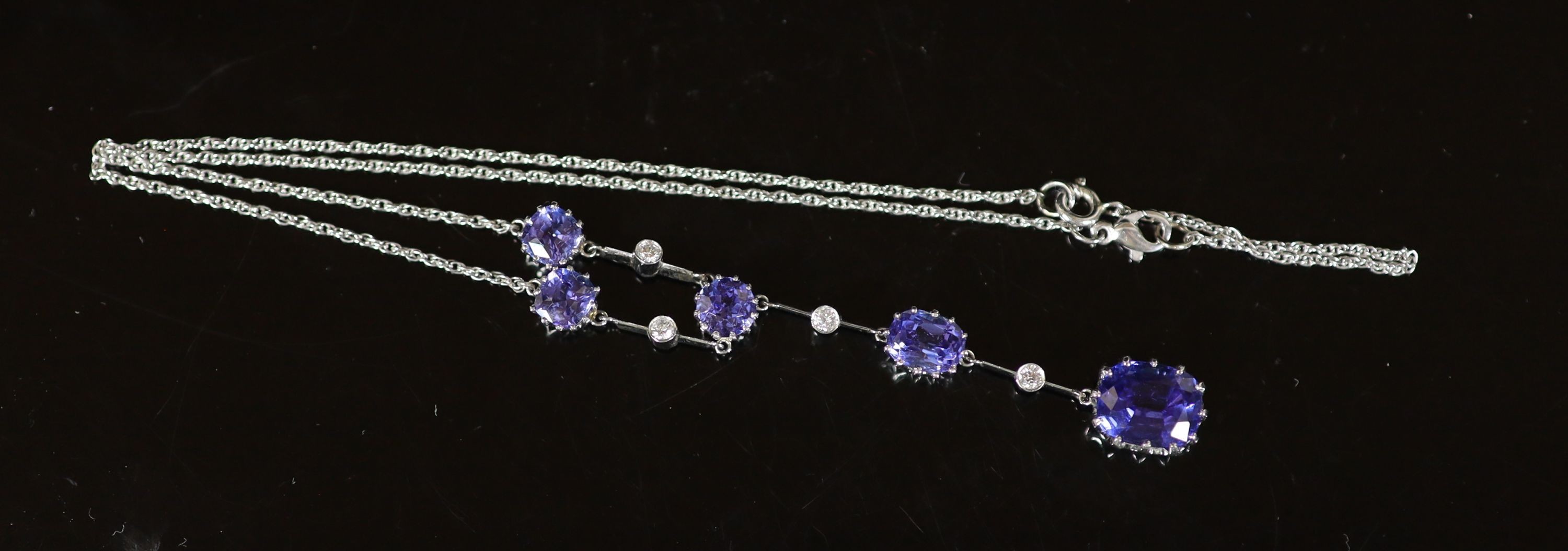 A modern platinum, five stone tanzanite and four small round cut diamond set drop pendant necklace, - Image 2 of 2