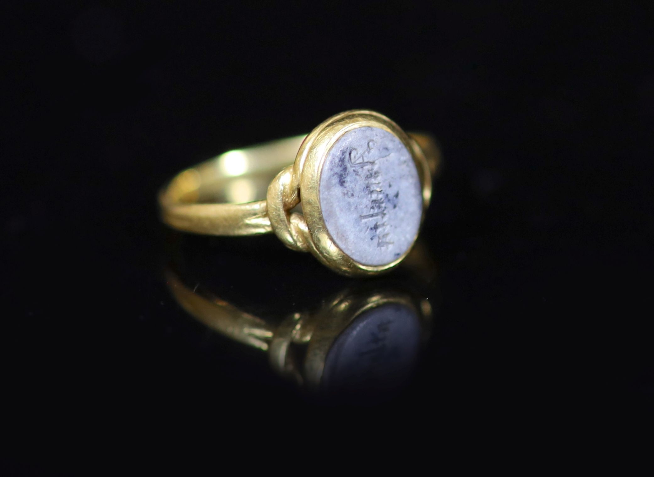 An antique gold and oval chalcedony set ring, carved with the name 'Amelia',size L, gross weight 2.3