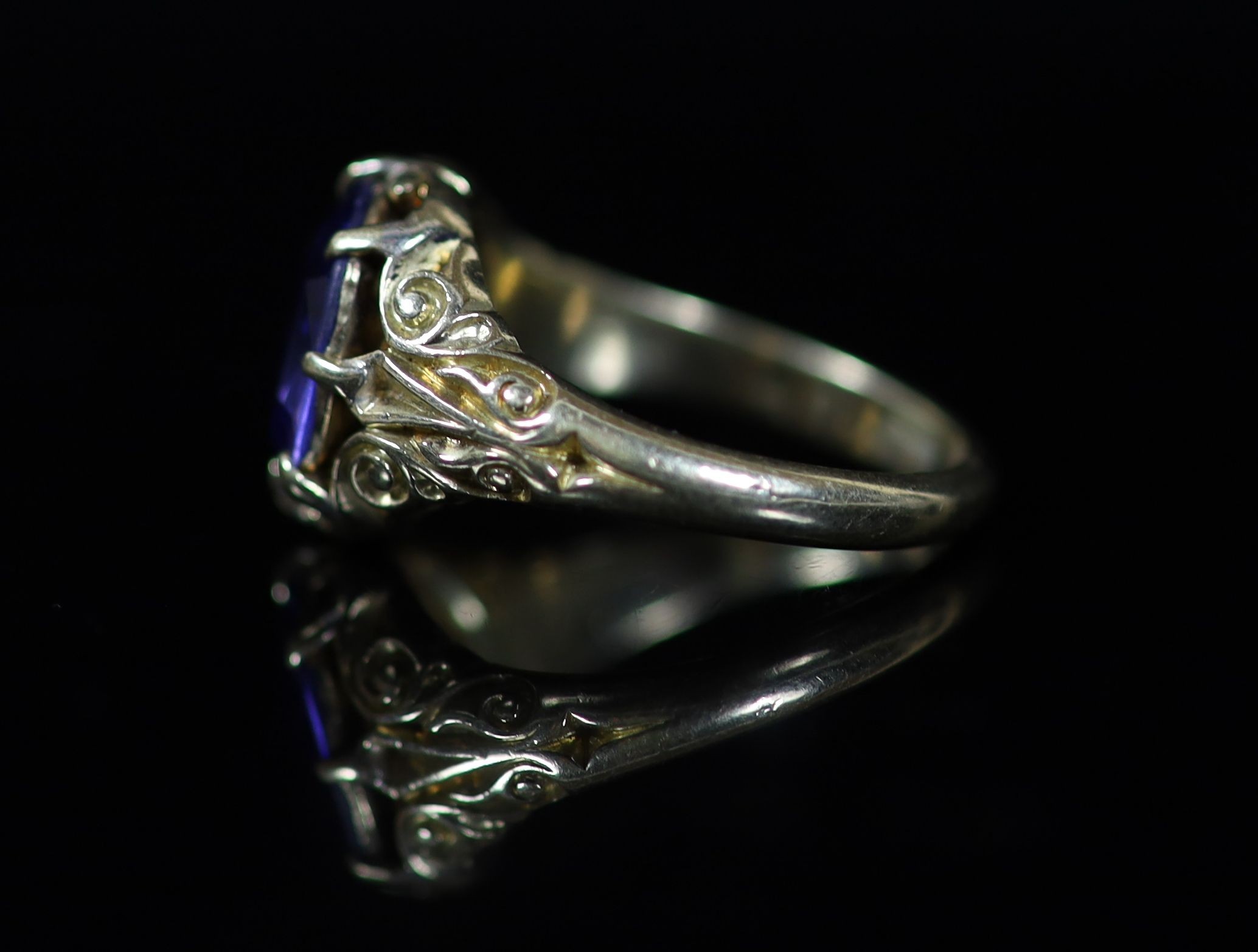 An 18ct gold and single stone claw set sapphire ring,with closed back setting and carved shoulders - Image 2 of 3