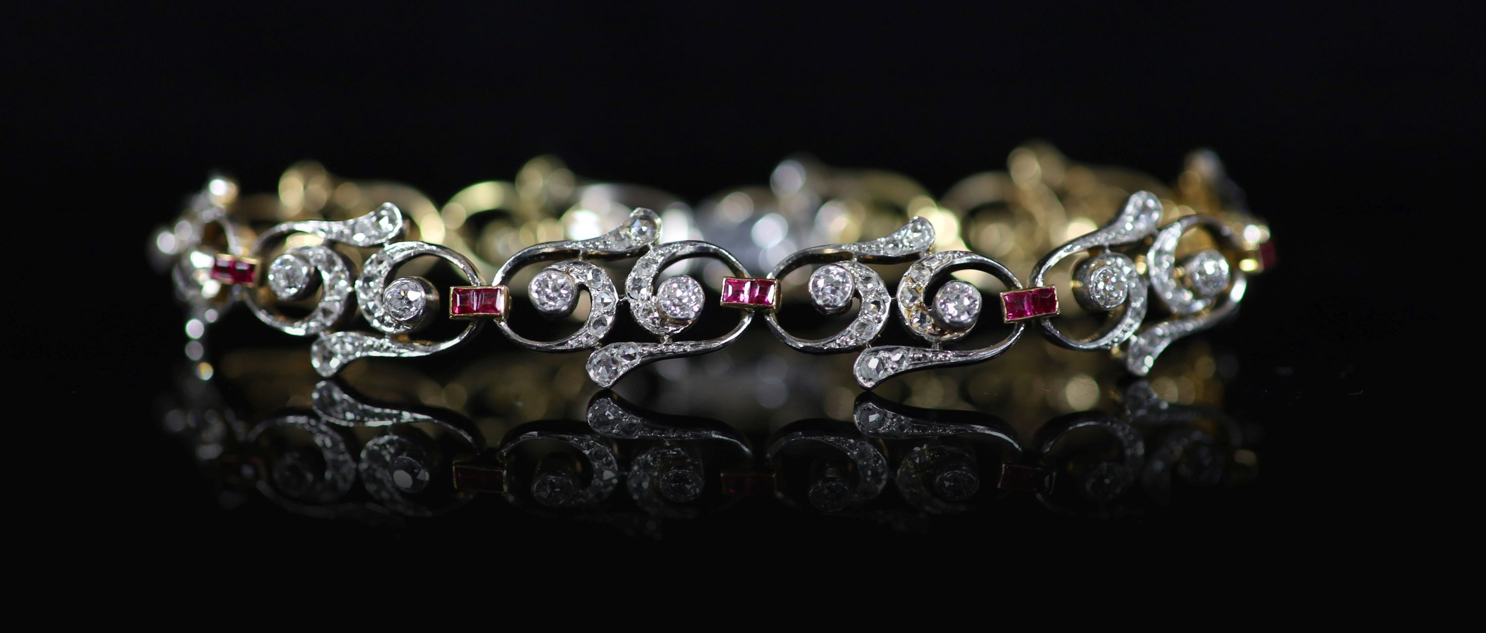 A 1940's/1950's gold and platinum, ruby and diamond set open work scroll link bracelet,18cm, gross