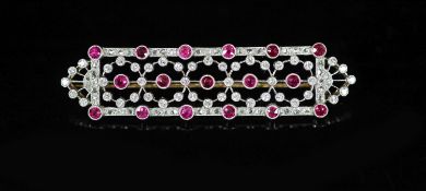 A 1920's/1930's style pierced gold and platinum, ruby and diamond chip millegrain set shaped