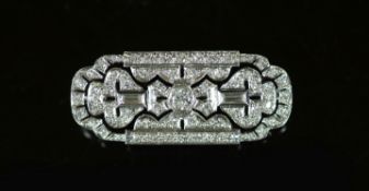 An Art Deco style pierced platinum, round and baguette cut diamond set shaped rectangular brooch,