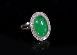 A 1920's 18ct white gold, oval cabochon jadeite and rose cut diamond millegrain set dress ring,