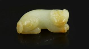 A Chinese pale celadon and russet jade figure of a lion dog,recumbent pose looking to its right,6.