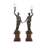 A pair of 19th century style bronze figural torcheres,each modelled as a classical maiden holding