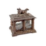 A late 19th century Black Forest carved wood liqueur casketmodelled as a garden house and surmounted