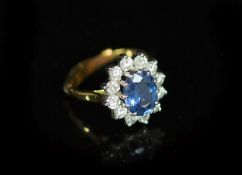 A modern 18ct gold, sapphire and diamond set oval cluster ring,with 9ct ring sizer, size L, gross